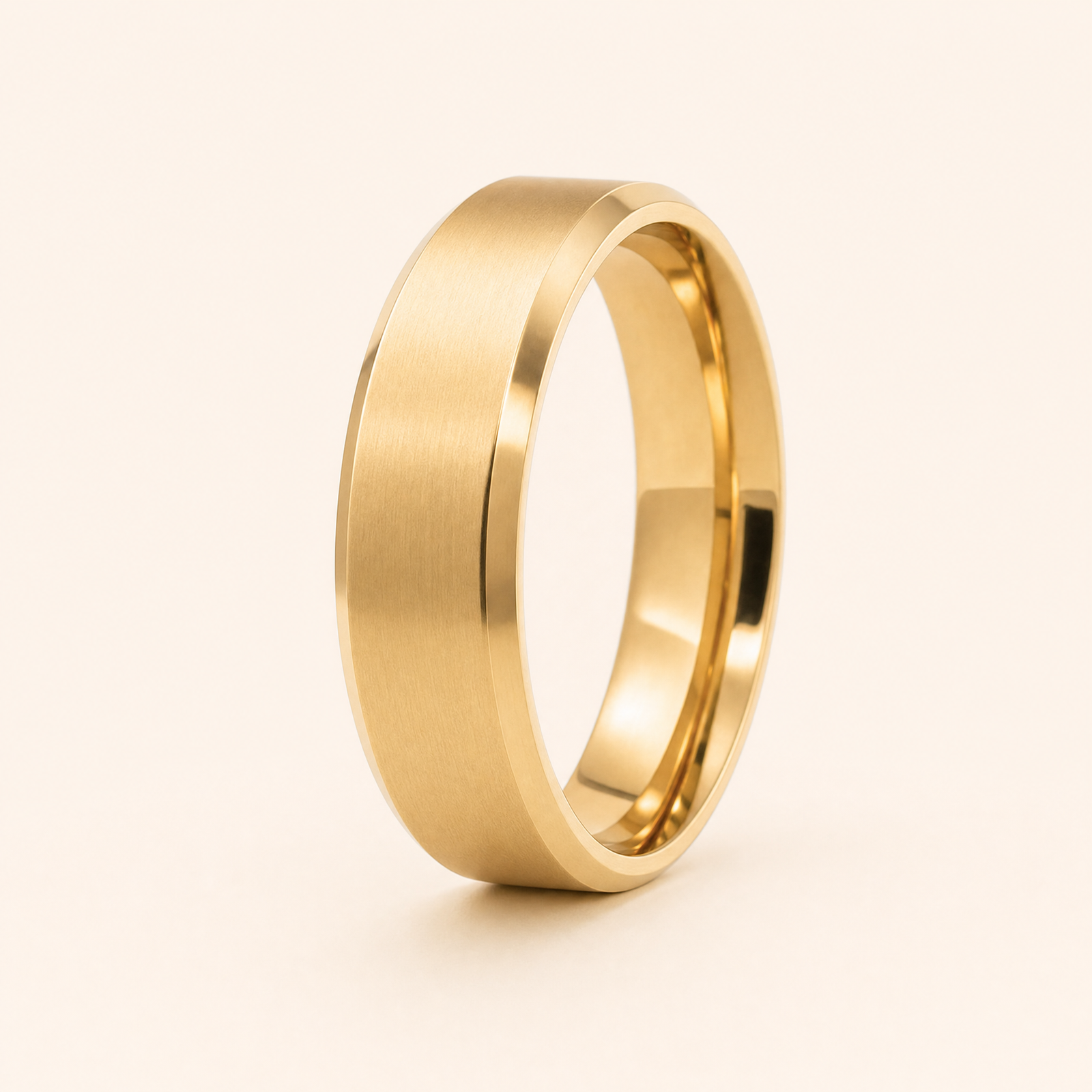 Gold · Matte — men's 5mm beveled wedding band with matte brushed finish standing on seamless ivory