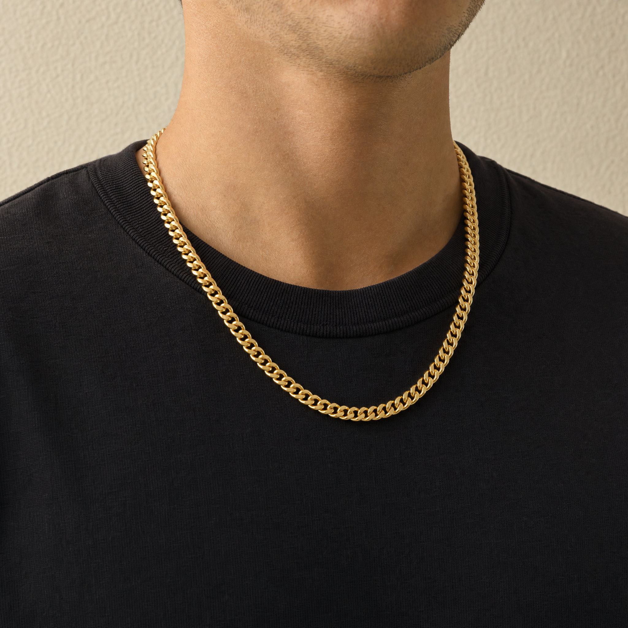 5mm gold Cuban chain worn on the neck over a black tee