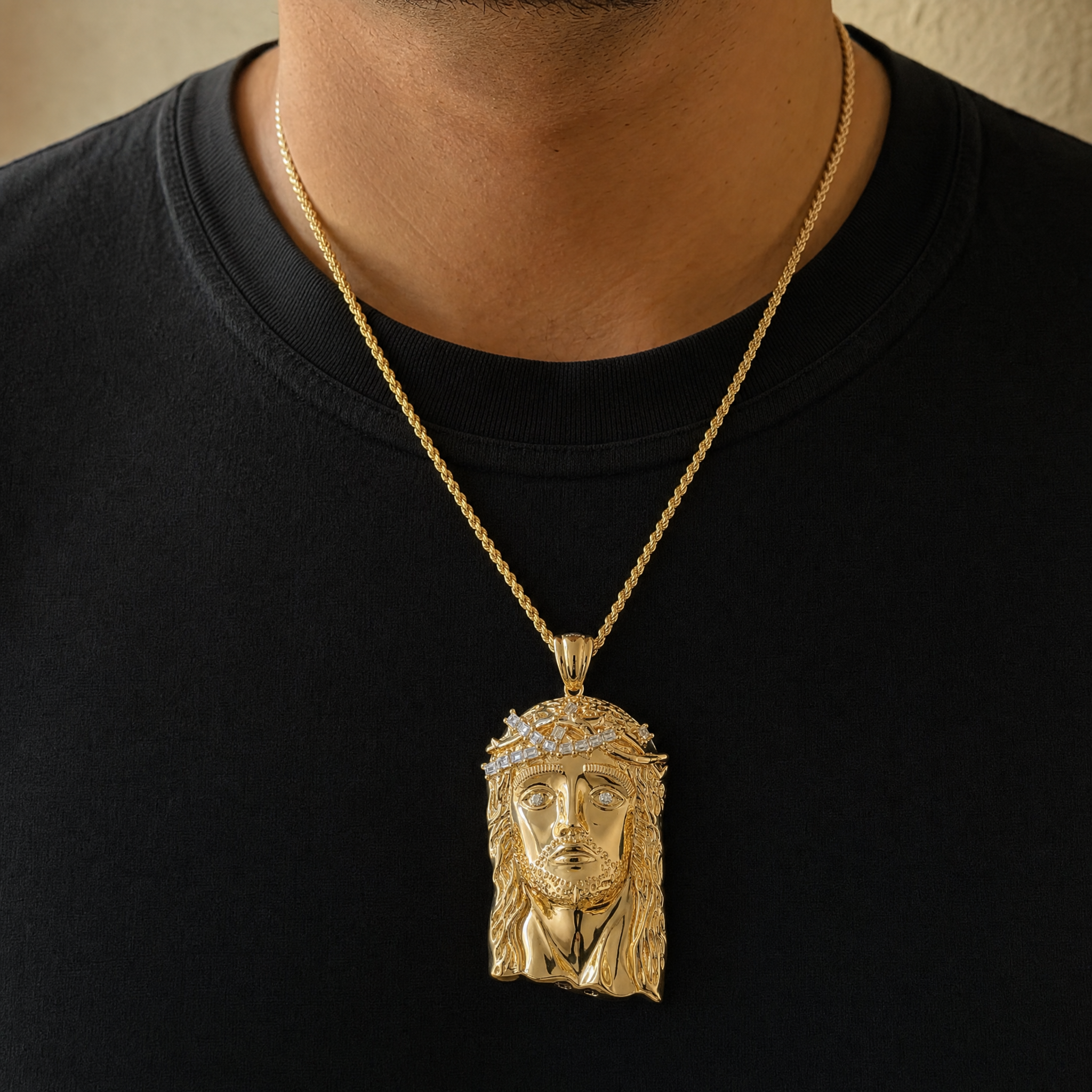 Gold Jesus pendant worn on the sternum over a black tee
