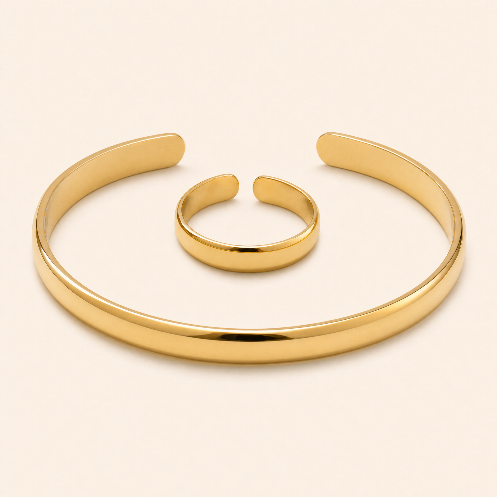Gold cuff bracelet and matching open ring on seamless ivory