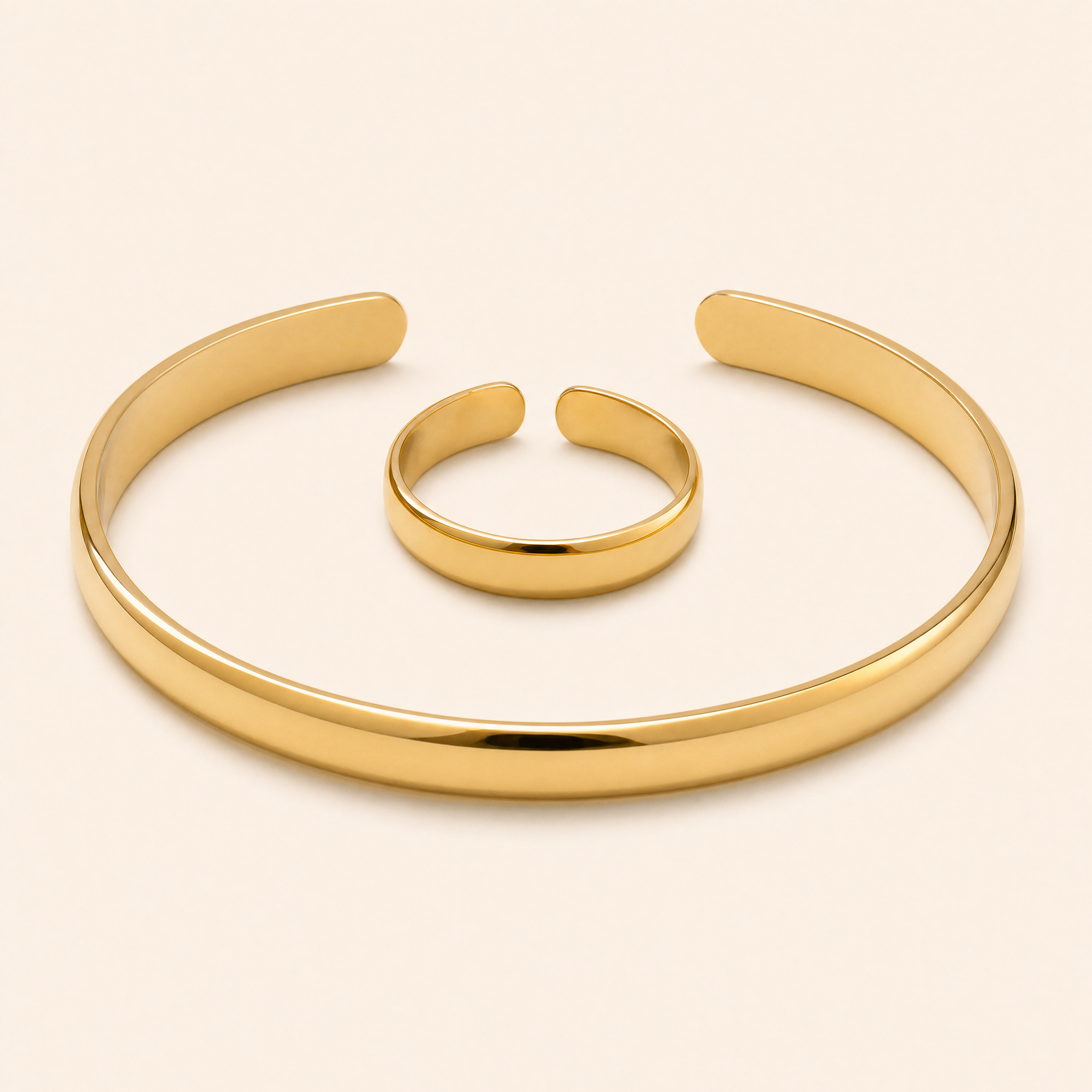 Gold cuff bracelet and matching open ring on seamless ivory