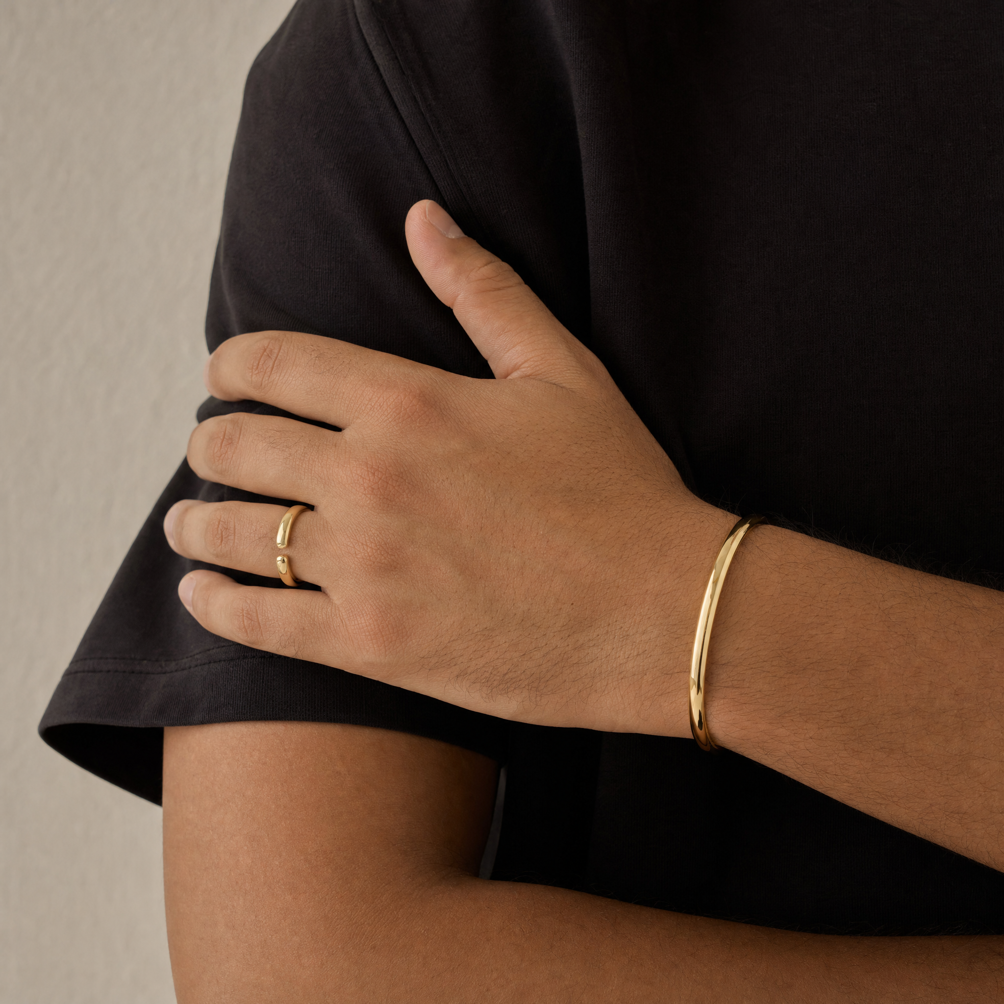 Gold ring and cuff shown at true size on a hand