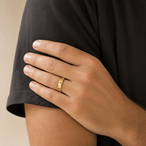 Gold beveled wedding band worn on the ring finger