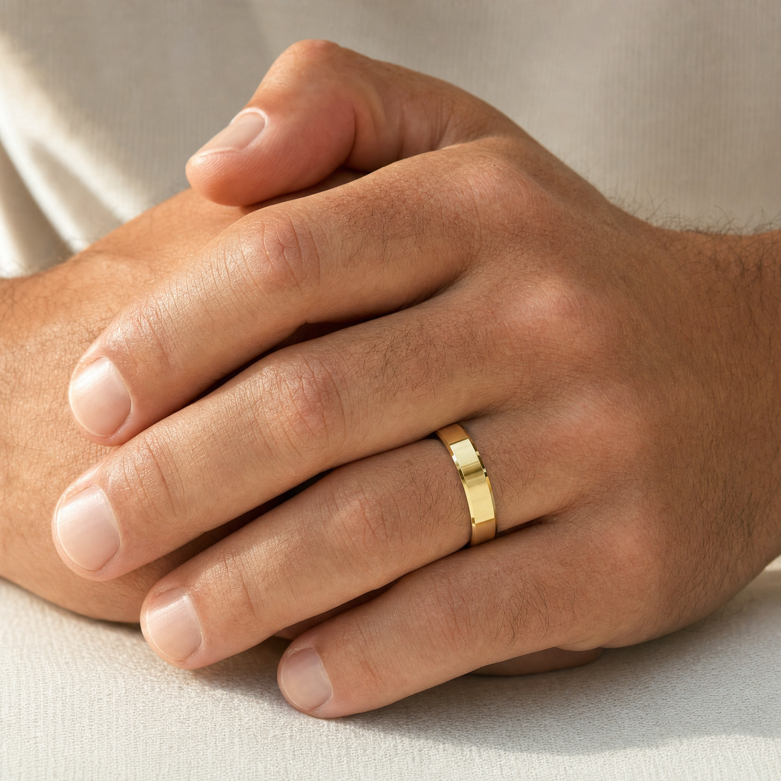 Beveled gold band shown at true size on clasped hands