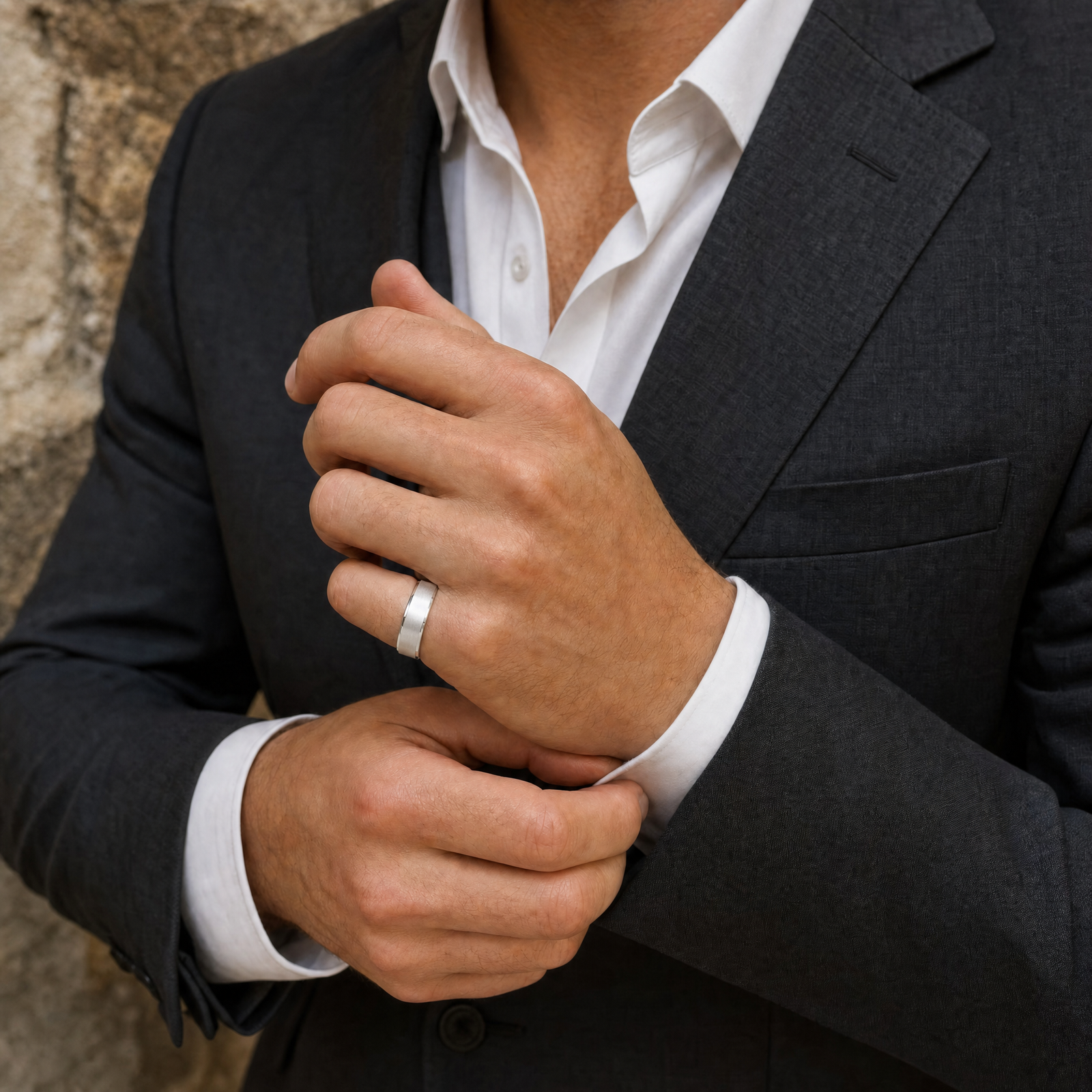 Silver · Matte — men's 5mm beveled matte brushed silver wedding band, groom in a charcoal suit wearing the band